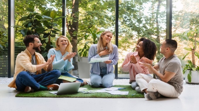 Group of people sitting together, smiling and participating in a supportive group therapy or wellness session.