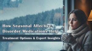 Woman sitting by a snowy window holding a warm drink, representing seasonal affective disorder treatment and mental health support.