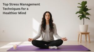 Woman meditating on a yoga mat indoors, representing stress management and mental wellness.