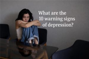 Woman sitting alone looking sad, representing early warning signs of depression and emotional distress